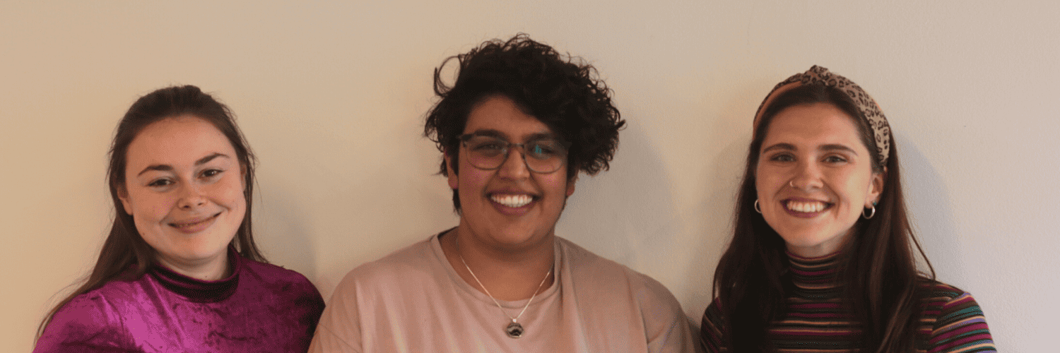 Pippa, Simran and Sophie Ford smile at the camera in front of a white wall.