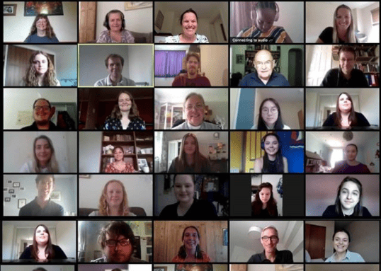 30 people smile at the camera on a video call.