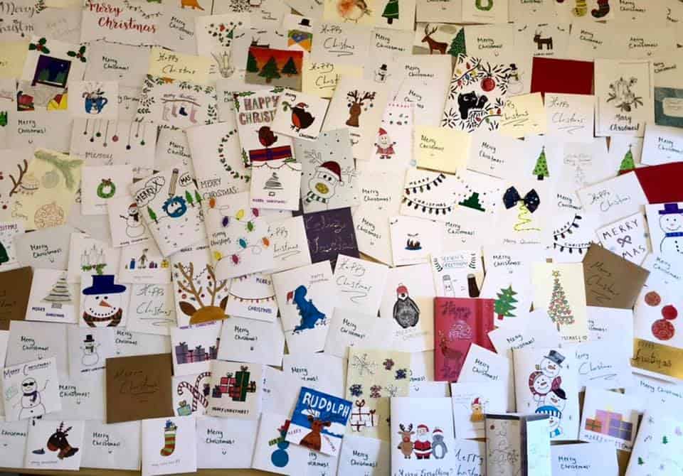 A picture of a collage of approximately 100 cards laid out on the floor. They are christmas card that were made for the Bristol Hub LinkAges xmas drive.