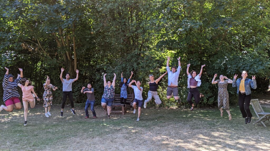 Student Hubs staff are outside. They are all in various stages of jumping. They all look happy.