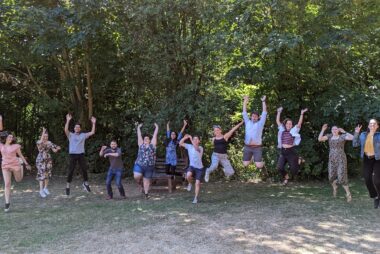 Student Hubs staff are outside. They are all in various stages of jumping. They all look happy.