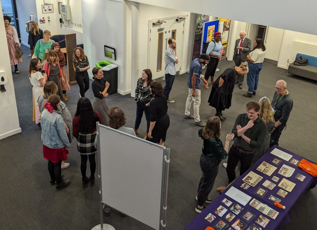 Individuals are mingling in a foyer. The photo is taken from above. 