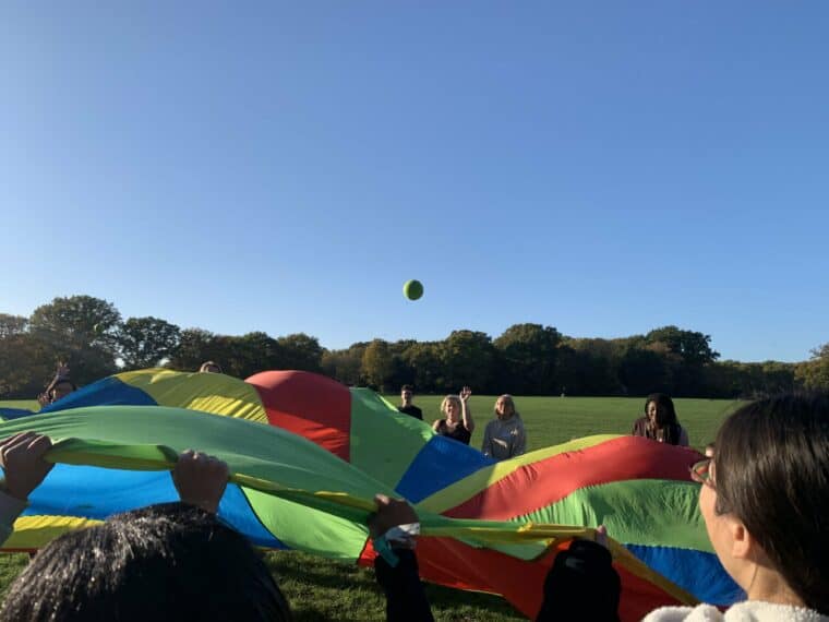 group of volunteers and young people playing the parachute game
