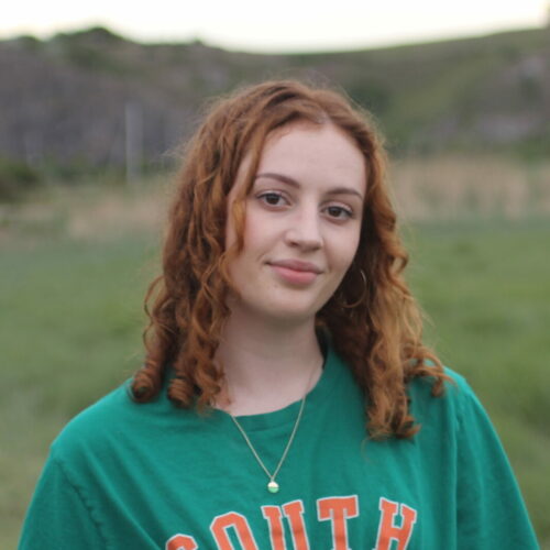 Amy Bond smiles at the camera, she is stood outdoors