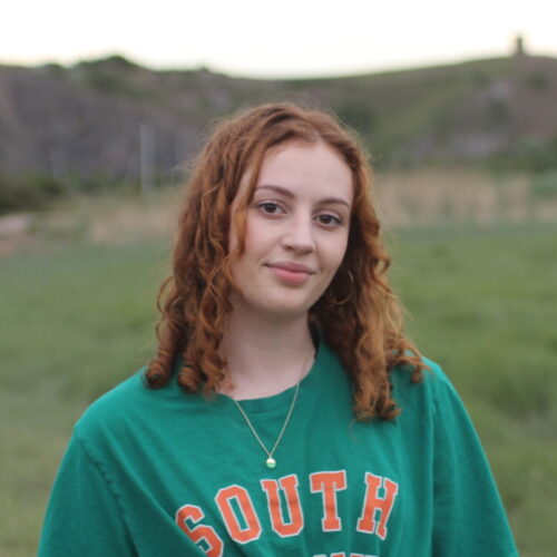An image of a young woman in a green tshirt.