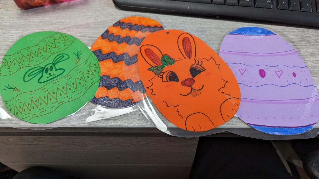 ID: colourful paper in the shape of eggs, decorated with easter designs by young people during Branch Up.